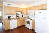 two bedroom apt. kitchen, light cabinets, white appliances